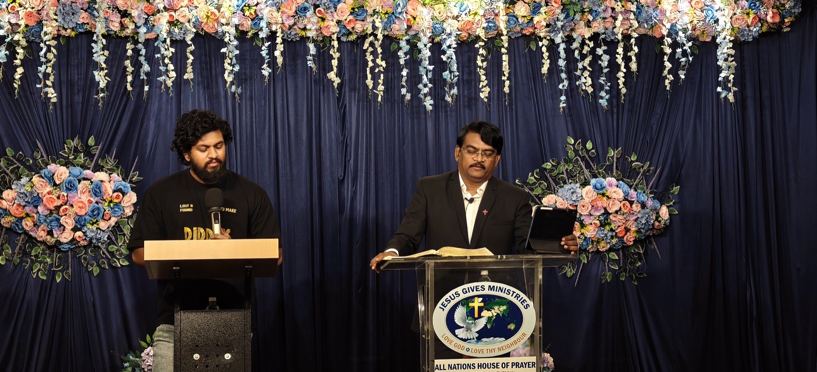 Rev. Dr. P. Arul Selvaraj reading the Bible with a translator during Sunday worship